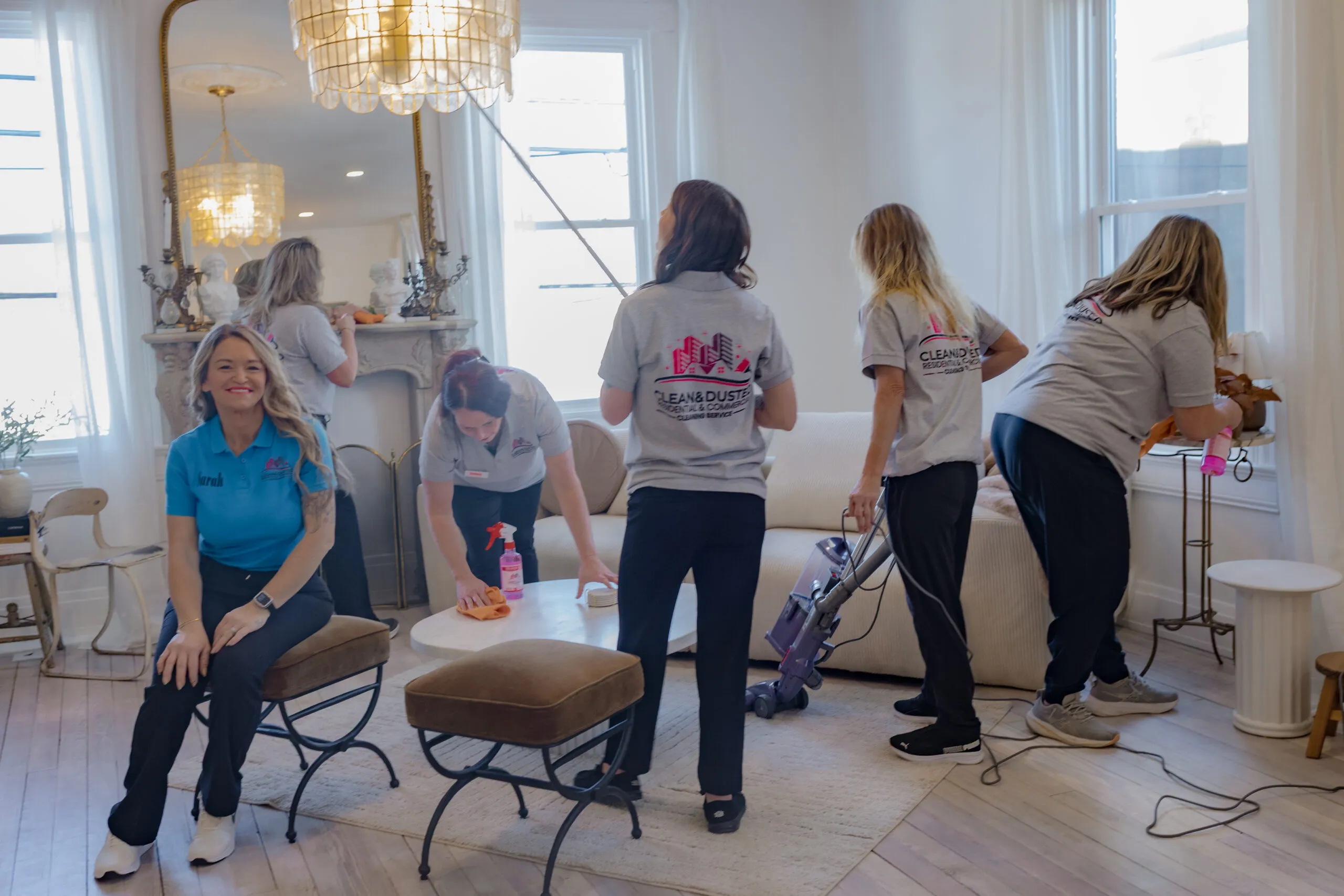 The owner of Clean & Dusted seated with her cleaning team in a bright living room
